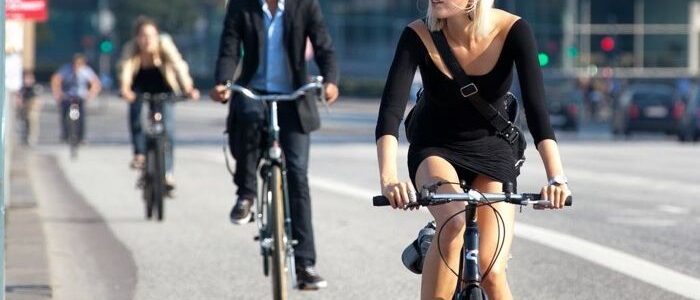 People cycling in a city bike lane, showcasing urban bike commuting.