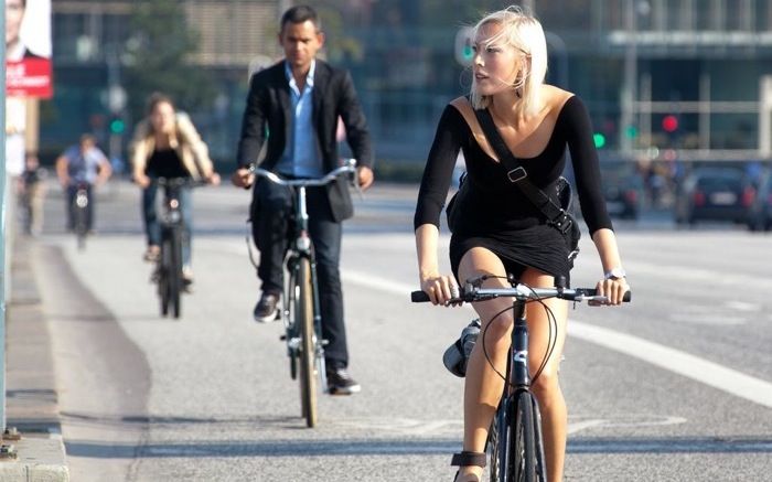 People cycling in a city bike lane, showcasing urban bike commuting.